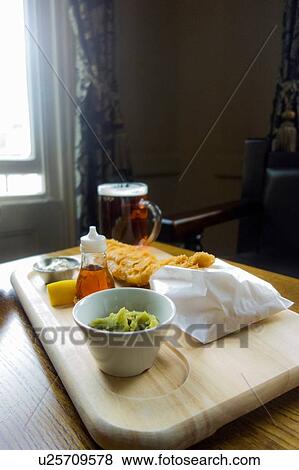 Stock Photo - Fish and chips served with beer in pub. Fotosearch