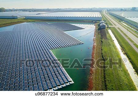 Floating solar panels installed on water supply of neighbouring greenhouses, elevated view, Netherlands View Large Photo Image Picture - Floating solar panels installed on water supply of neighbouring greenhouses, elevated view, Netherlands. Fotosearch