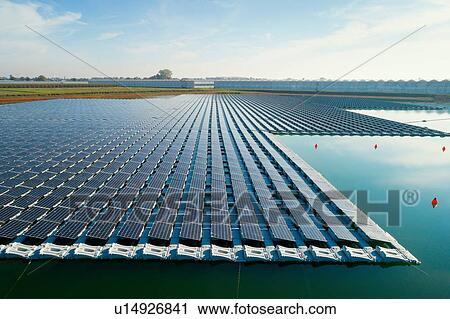 Stock Image - Floating solar panels installed on water supply of neighbouring greenhouses, elevated view, Netherlands. Fotosearch