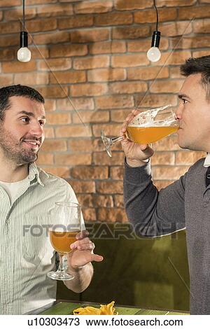 Friends drinking beer in a pub View Large Photo Image Stock Image - Friends drinking beer in a pub. Fotosearch