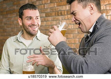 Friends drinking beer in a pub View Large Photo Image Stock Photo - Friends drinking beer in a pub. Fotosearch