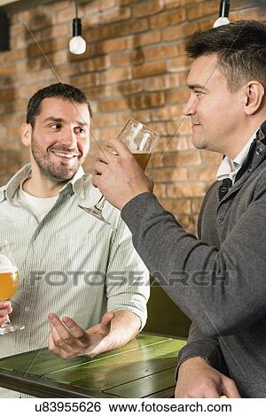 Friends drinking beer in a pub View Large Photo Image Stock Photograph - Friends drinking beer in a pub. Fotosearch