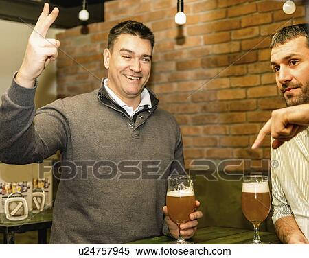 Stock Photography - Friends drinking beer in a pub. Fotosearch