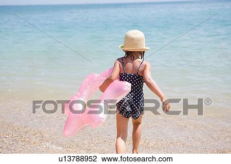 Girl carrying pink inflatable into sea, Scopello, Sicily, Italy View Large Photo Image Stock Image - Girl carrying pink inflatable into sea, Scopello, Sicily, Italy. Fotosearch