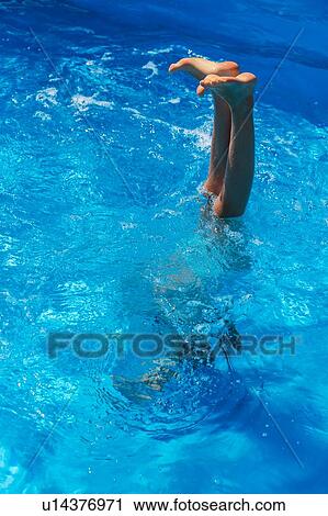 Girl doing handstand in outdoor swimming pool, legs and feet out of water, Vernazza, Liguria, Italy View Large Photo Image Stock Image - Girl doing handstand in outdoor swimming pool, legs and feet out of water, Vernazza, Liguria, Italy. Fotosearch