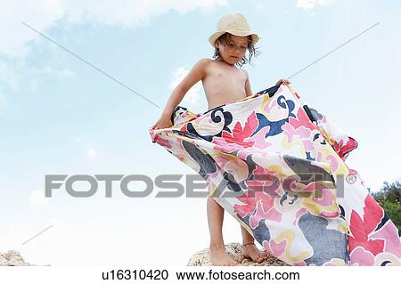 Girl standing on rock folding patterned blanket, Scopello, Sicily, Italy View Large Photo Image Stock Image - Girl standing on rock folding patterned blanket, Scopello, Sicily, Italy. Fotosearch