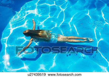 Stock Photo - Girl swimming underwater in outdoor swimming pool, high angle view, Vernazza, Liguria, Italy. Fotosearch