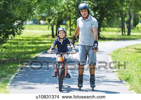 Grandfather and grandson biking and roller skating View Large Photo Image Picture - Grandfather and grandson biking and roller skating. Fotosearch