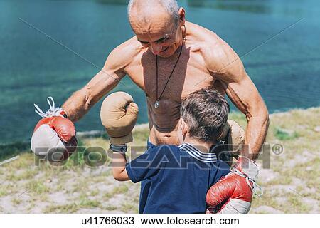 Stock Image - Grandfather and grandson boxing. Fotosearch