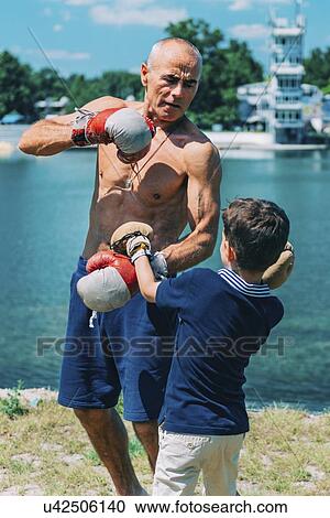 Stock Image - Grandfather and grandson boxing. Fotosearch