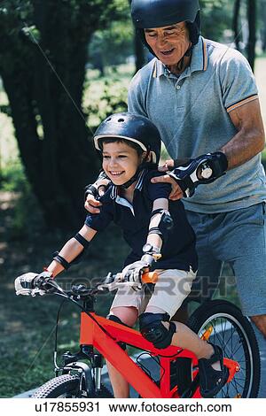 Stock Image - Grandfather and grandson enjoy roller skating and biking. Fotosearch