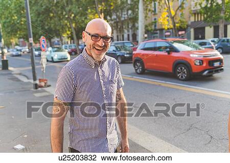 Stock Image - Happy mature man on city street, portrait. Fotosearch