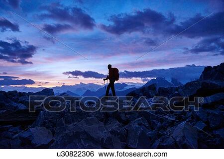 Stock Photograph - Hiker at dusk, Mont Cervin, Matterhorn, Valais, Switzerland. Fotosearch