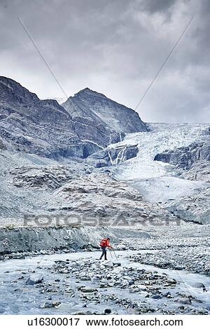 Stock Photo - Hiker moving across rocky terrain, Mont Cervin, Matterhorn, Valais, Switzerland. Fotosearch
