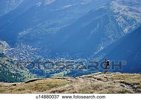 Hiker on grassy cliff overlooking valley, Mont Cervin, Matterhorn, Valais, Switzerland View Large Photo Image Stock Photo - Hiker on grassy cliff overlooking valley, Mont Cervin, Matterhorn, Valais, Switzerland. Fotosearch