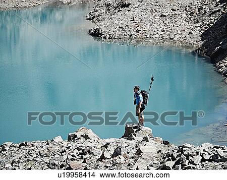 Picture - Hiker on rock by edge of lake, Mont Cervin, Matterhorn, Valais, Switzerland. Fotosearch