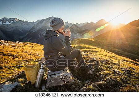 Hiker taking break with warm drink, Karwendel region, Hinterriss, Tirol, Austria View Large Photo Image Stock Image - Hiker taking break with warm drink, Karwendel region, Hinterriss, Tirol, Austria. Fotosearch