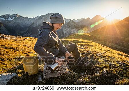 Hiker taking break with warm drink, Karwendel region, Hinterriss, Tirol, Austria View Large Photo Image Stock Photo - Hiker taking break with warm drink, Karwendel region, Hinterriss, Tirol, Austria. Fotosearch
