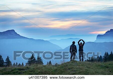 Hikers enjoying view of misty mountains, Manigod, Rhone-Alpes, France View Large Photo Image Stock Photography - Hikers enjoying view of misty mountains, Manigod, Rhone-Alpes, France. Fotosearch