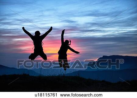 Stock Image - Hikers jumping for joy, Manigod, Rhone-Alpes, France. Fotosearch