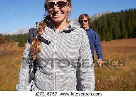 Stock Photo - Hikers on grassy field, Manigod, Rhone-Alpes, France. Fotosearch