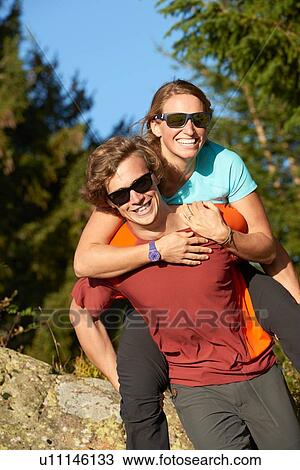 Stock Image - Hikers playing piggyback. Fotosearch
