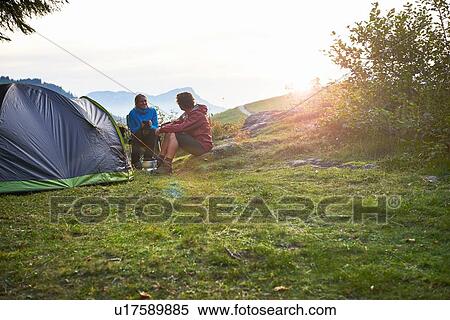 Hikers relaxing by tent, Manigod, Rhone-Alpes, France View Large Photo Image Stock Photography - Hikers relaxing by tent, Manigod, Rhone-Alpes, France. Fotosearch