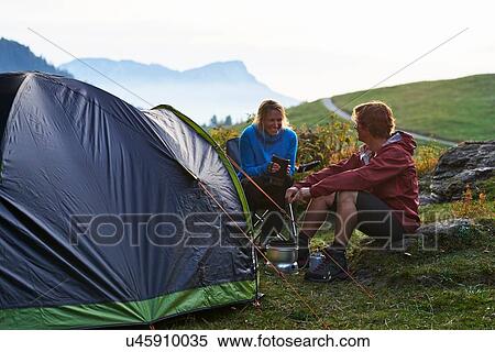 Hikers relaxing by tent, Manigod, Rhone-Alpes, France View Large Photo Image Stock Photography - Hikers relaxing by tent, Manigod, Rhone-Alpes, France. Fotosearch