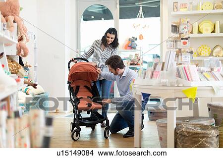 Picture - Husband and pregnant wife shopping for pram. Fotosearch