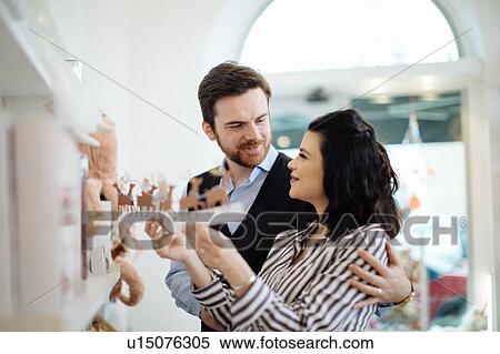 Stock Photography - Husband and pregnant wife shopping for educational toys. Fotosearch