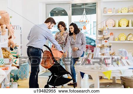 Stock Photography - Husband and pregnant wife shopping for pram. Fotosearch
