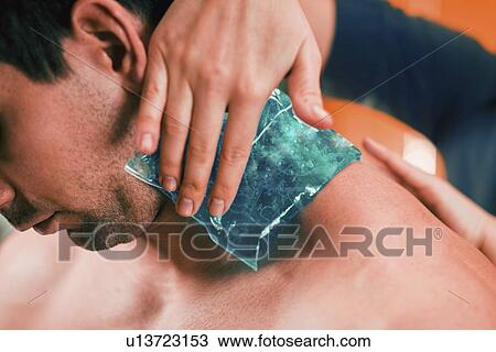 Stock Image - Ice pack on painful neck. Fotosearch