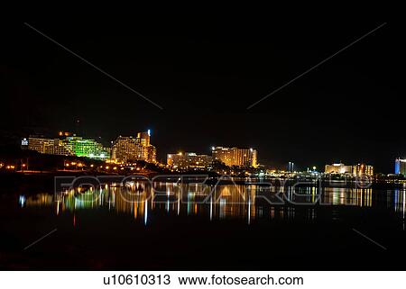 Stock Image - Illuminated hotels, with light reflecting in the Dead Sea at night, Ein Bokek, Israel (view from south). Fotosearch