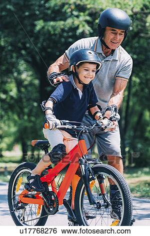Learning how to ride a bike View Large Photo Image Stock Photograph - Learning how to ride a bike. Fotosearch