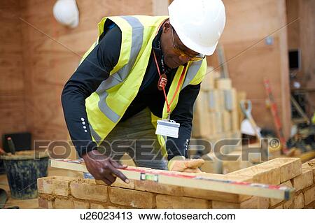 Stock Image - Lecturer building brick wall in classroom. Fotosearch