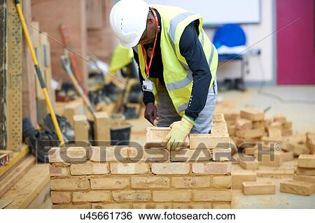 Stock Photograph - Lecturer building brick wall in classroom. Fotosearch