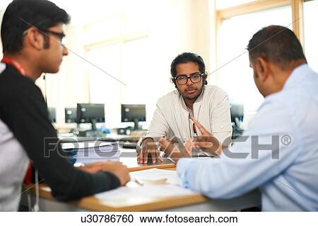 Stock Image - Lecturer talking to college students in classroom. Fotosearch