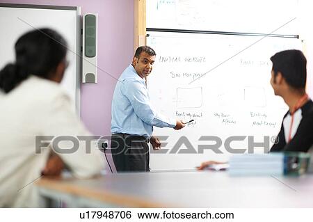 Stock Photograph - Lecturer talking to college students in classroom. Fotosearch