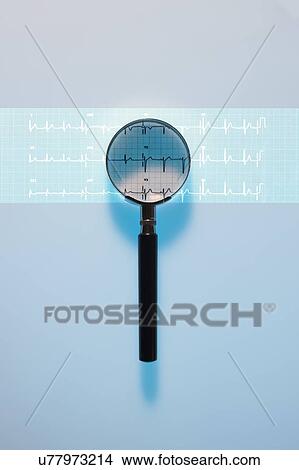 Picture - Magnifying glass and electrocardiagram (ECG). An ECG measures the electrical activity of the heart. Composite image.. Fotosearch