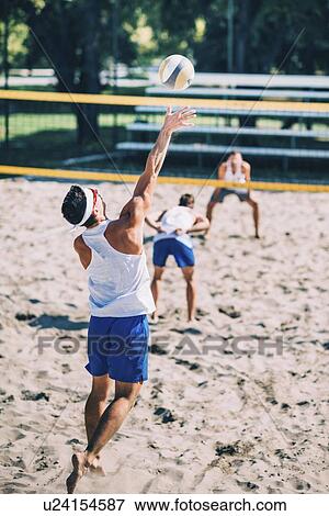 Stock Photo - Male beach volleyball players in action. Fotosearch