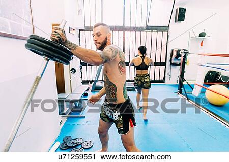 Stock Image - Male boxer lifting weights. Fotosearch