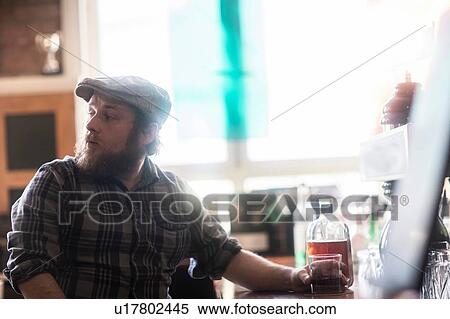 Male customer looking over his shoulder in traditional Irish public house View Large Photo Image Stock Photography - Male customer looking over his shoulder in traditional Irish public house. Fotosearch