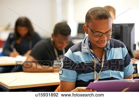 Male higher education student reading file in college classroom View Large Photo Image Stock Image - Male higher education student reading file in college classroom. Fotosearch