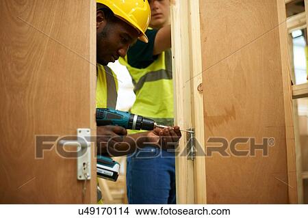 Male higher education students drilling wooden doorway in college workshop View Large Photo Image Picture - Male higher education students drilling wooden doorway in college workshop. Fotosearch