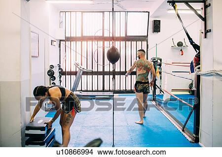 Picture - Man and woman getting ready for workout in gym. Fotosearch