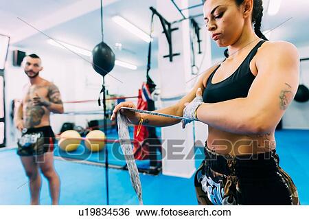 Stock Photograph - Man and woman getting ready for workout in gym. Fotosearch