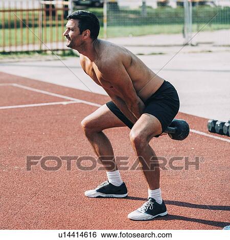Stock Photograph - Man doing kettle bell swing. Fotosearch