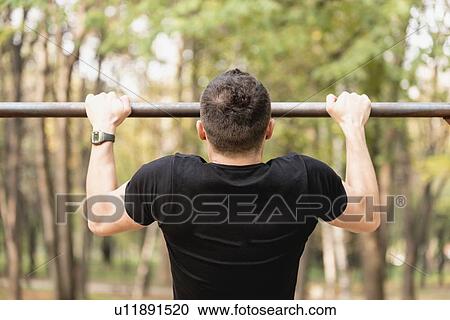 Stock Image - Man doing pull ups. Fotosearch