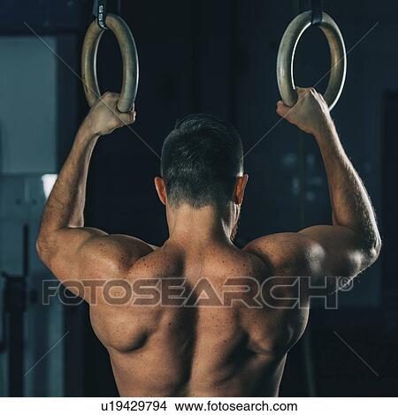 Picture - Man exercising on gymnastic rings. Fotosearch