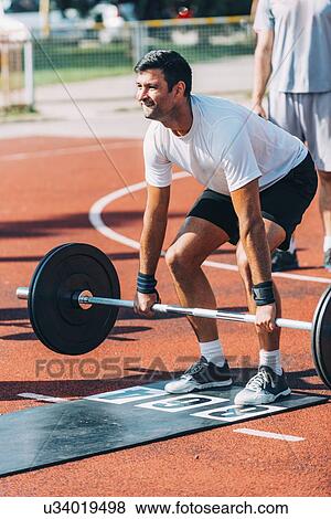 Man lifting barbell View Large Photo Image Stock Photo - Man lifting barbell. Fotosearch